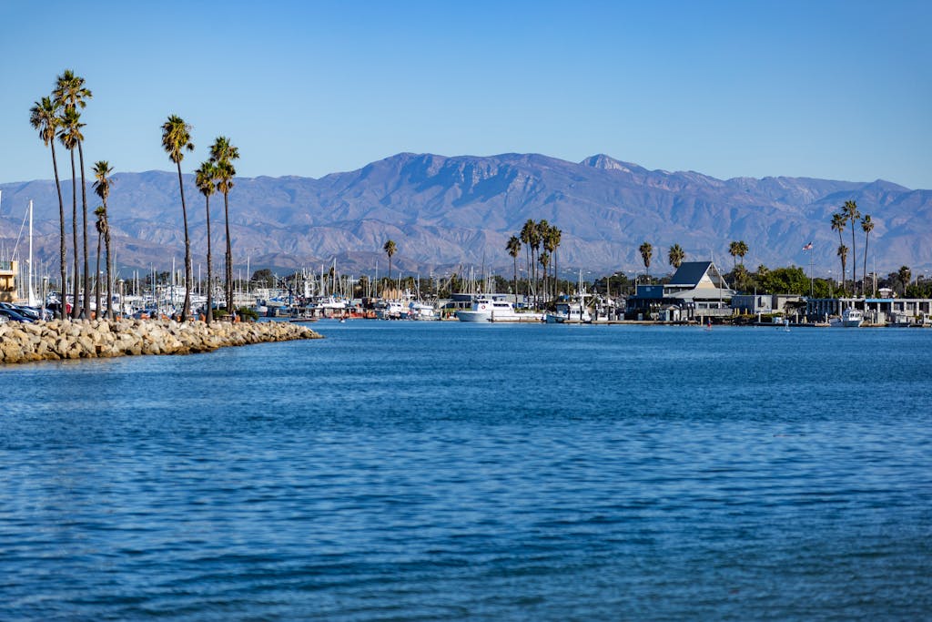 Beautiful view of Channel Islands Harbor in Oxnard, CA with palm trees and mountains in the background.